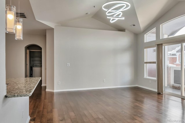 14251 E 1st Dr Unit 308, Aurora, CO 80011 - unfurnished living room with arched walkways, dark wood-style flooring, baseboards, vaulted ceiling, and a chandelier