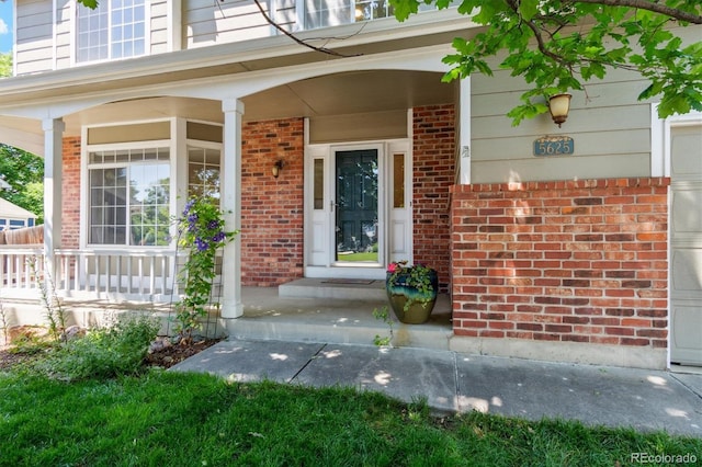 5625 W 109th Cir, Westminster, CO 80020 - doorway to property featuring covered porch and brick siding