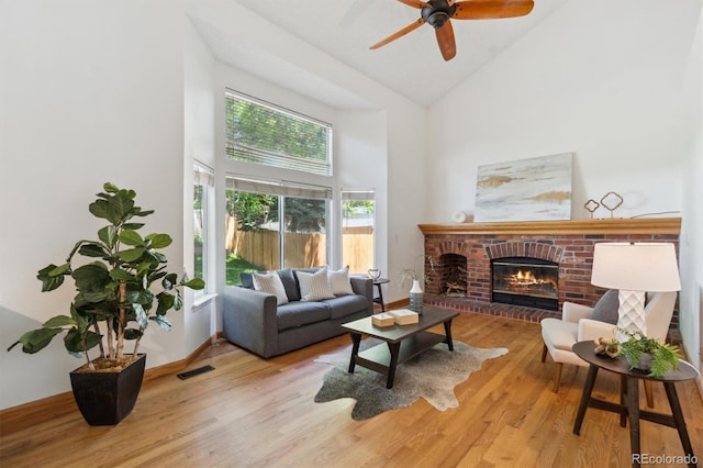 5625 W 109th Cir, Westminster, CO 80020 - living room with high vaulted ceiling, a fireplace, light wood-style floors, and a ceiling fan