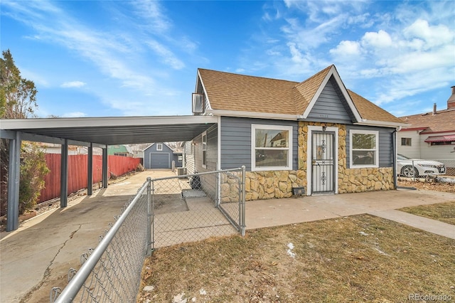 view of front facade with an outbuilding, a carport, and a garage