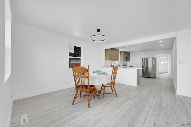 dining space with light hardwood / wood-style flooring