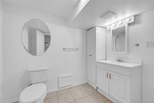 bathroom with tile patterned floors, toilet, a textured ceiling, and vanity