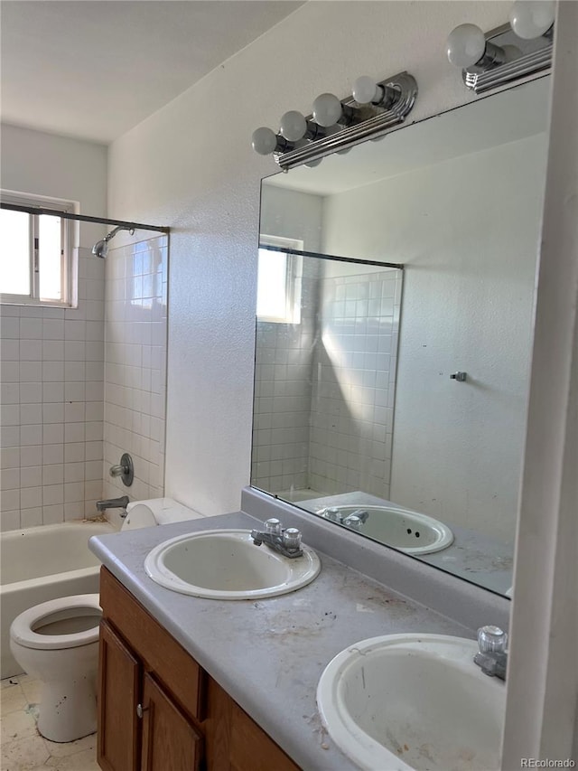 full bathroom featuring toilet, vanity, and tiled shower / bath