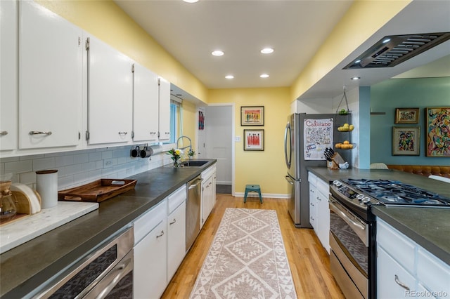 4891 Depew St, Denver, CO 80212 - kitchen featuring appliances with stainless steel finishes, light wood finished floors, white cabinetry, backsplash, and recessed lighting