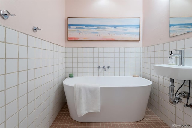 4891 Depew St, Denver, CO 80212 - bathroom featuring tile walls, a freestanding bath, tile patterned floors, and a wainscoted wall