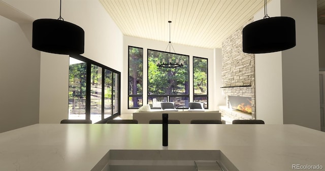 7142 Lynx Lair Rd, Evergreen, CO 80439 - dining space featuring a stone fireplace and wood ceiling