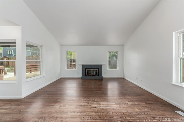 2026 S Pitkin St, Aurora, CO 80013 - unfurnished living room with lofted ceiling, dark wood-type flooring, a brick fireplace, and baseboards
