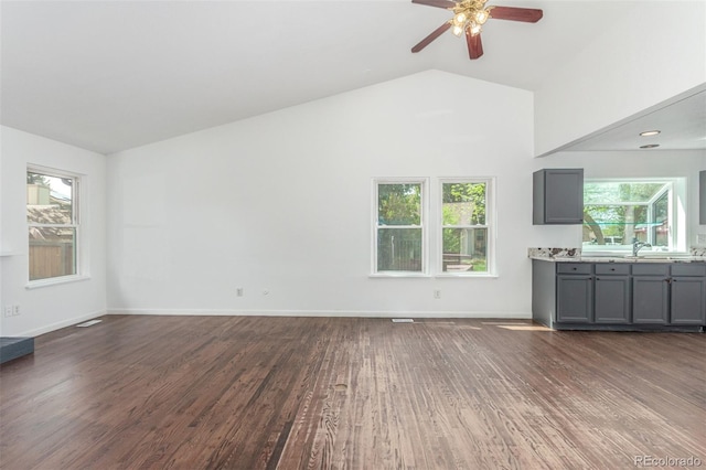 2026 S Pitkin St, Aurora, CO 80013 - unfurnished living room featuring wood finished floors, plenty of natural light, a ceiling fan, lofted ceiling, and baseboards