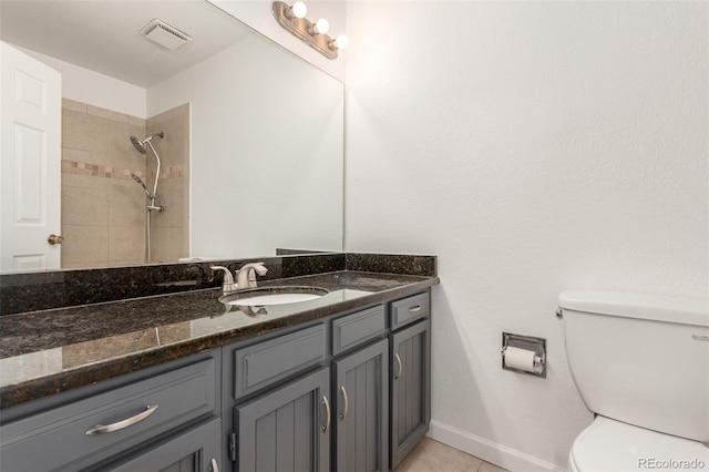 2026 S Pitkin St, Aurora, CO 80013 - full bathroom featuring toilet, vanity, tiled shower, tile patterned flooring, and baseboards