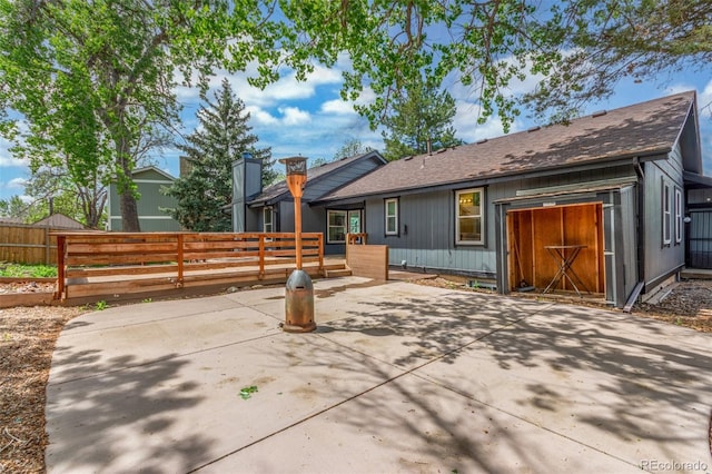 2026 S Pitkin St, Aurora, CO 80013 - rear view of property with fence, a patio, a deck, a shingled roof, and a chimney