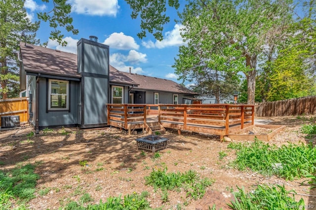 2026 S Pitkin St, Aurora, CO 80013 - rear view of property featuring fence, a deck, a chimney, a vegetable garden, and central air condition unit