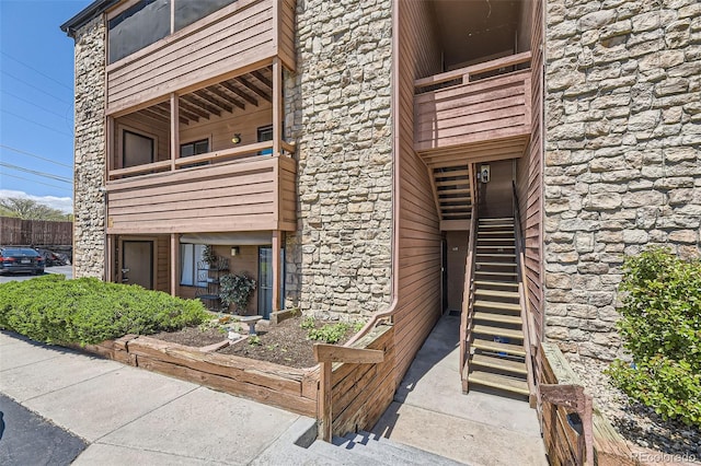 view of building exterior featuring stairs and fence