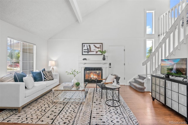 1248 W 135th Ave, Denver, CO 80234 - living area with high vaulted ceiling, wood finished floors, stairway, beamed ceiling, and healthy amount of natural light