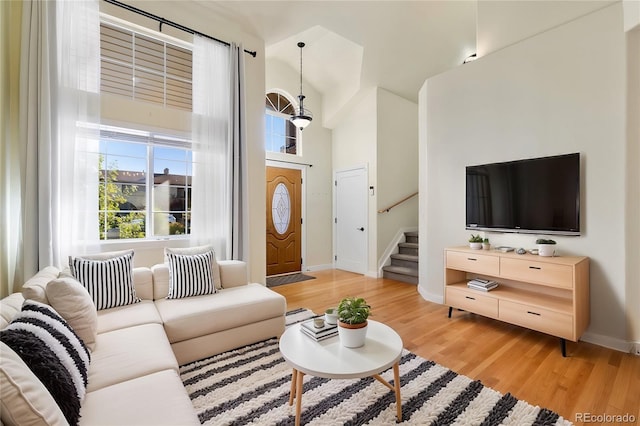 living room with light wood-type flooring and a high ceiling