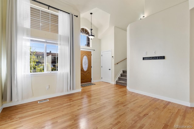 entryway with a high ceiling and light wood-type flooring