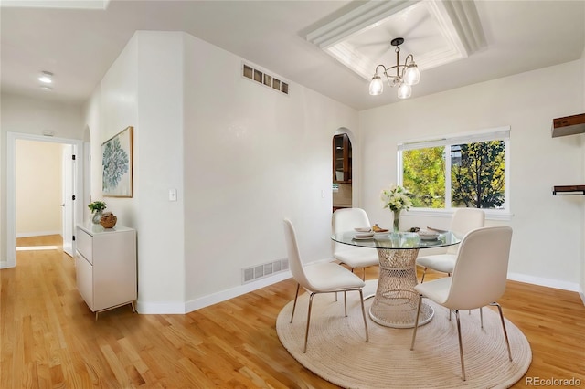 dining space with a notable chandelier and light wood-type flooring