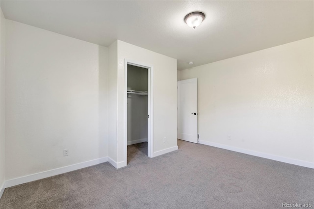 unfurnished bedroom featuring light carpet and a closet