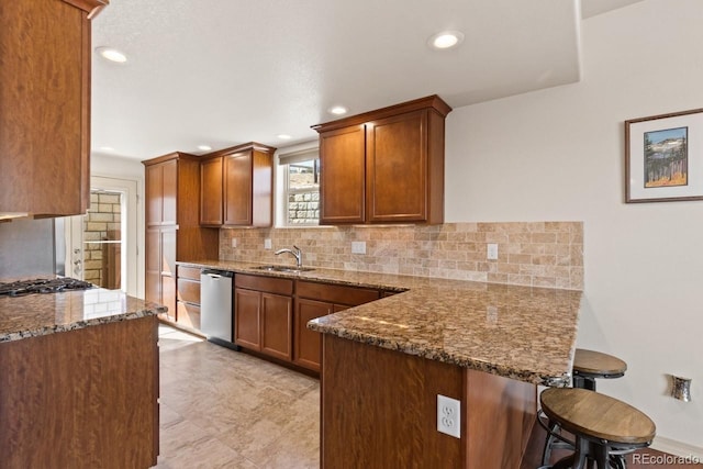 5703 Canyon Reserve Hts, Colorado Springs, CO 80919 - kitchen featuring a breakfast bar, dishwasher, dark stone counters, a peninsula, and tasteful backsplash
