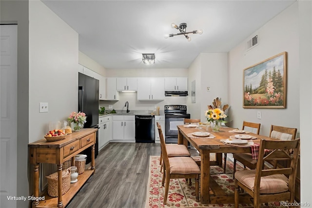 8843 Colorado Blvd Unit 208, Thornton, CO 80229 - kitchen featuring black appliances, wood finished floors, white cabinets, under cabinet range hood, and light countertops