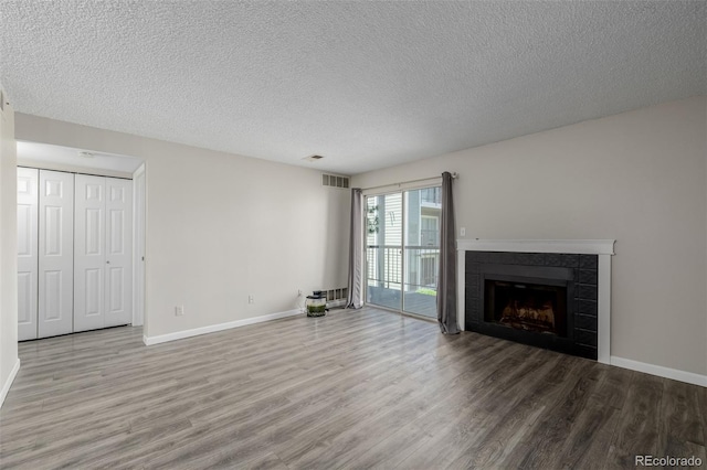 8843 Colorado Blvd Unit 208, Thornton, CO 80229 - unfurnished living room with wood finished floors, a textured ceiling, and a fireplace