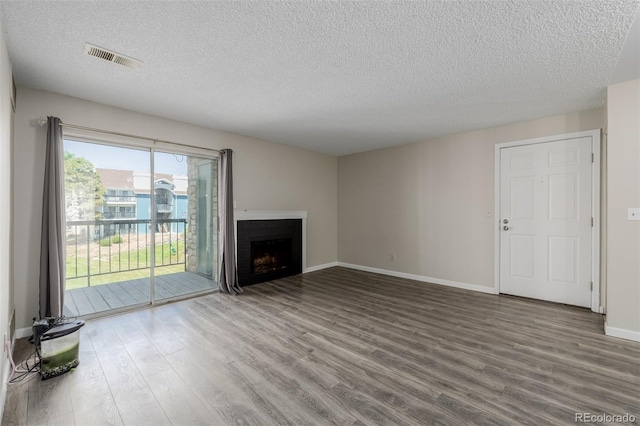8843 Colorado Blvd Unit 208, Thornton, CO 80229 - unfurnished living room with wood finished floors, a textured ceiling, and a fireplace