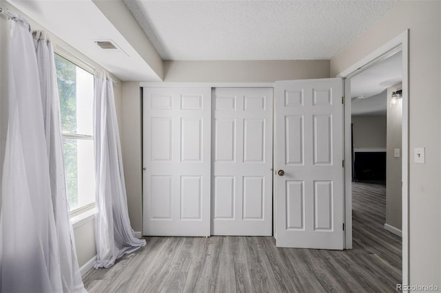8843 Colorado Blvd Unit 208, Thornton, CO 80229 - unfurnished bedroom featuring wood finished floors, a textured ceiling, and a closet