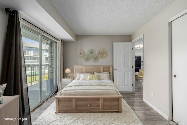8843 Colorado Blvd Unit 208, Thornton, CO 80229 - bedroom with access to outside, a textured ceiling, and wood finished floors