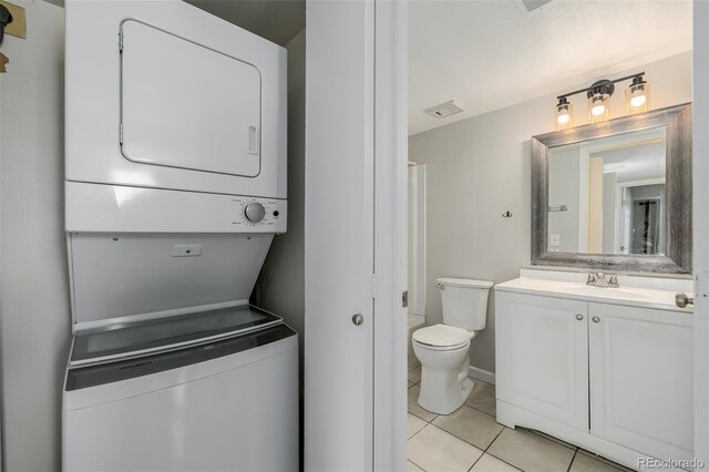 8843 Colorado Blvd Unit 208, Thornton, CO 80229 - full bath with stacked washing machine and dryer, tile patterned floors, and vanity