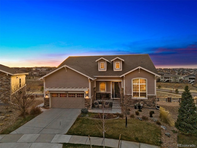 craftsman inspired home with a garage, covered porch, and a yard