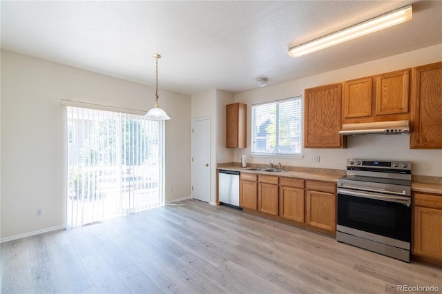 24664 E Louisiana Cir, Aurora, CO 80018 - kitchen with appliances with stainless steel finishes, under cabinet range hood, light wood-style floors, light countertops, and a sink