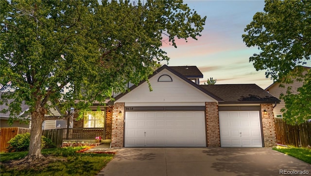 9638 Marion Way, Thornton, CO 80229 - view of front of property with a garage, concrete driveway, brick siding, and fence