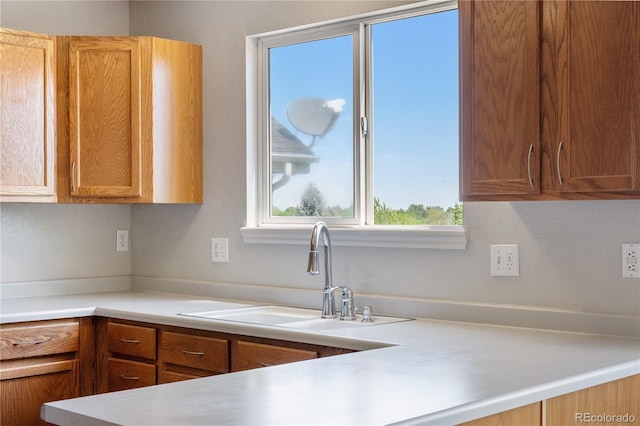 9638 Marion Way, Thornton, CO 80229 - kitchen featuring a sink, light countertops, and brown cabinets