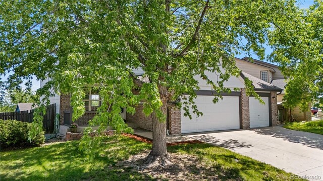 9638 Marion Way, Thornton, CO 80229 - obstructed view of property featuring driveway, fence, a garage, and brick siding