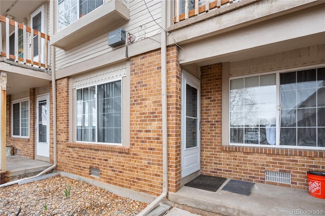 doorway to property with crawl space and brick siding