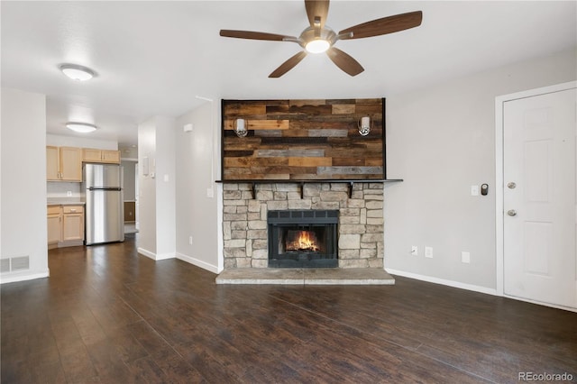 unfurnished living room with dark wood-style flooring, baseboards, ceiling fan, and visible vents