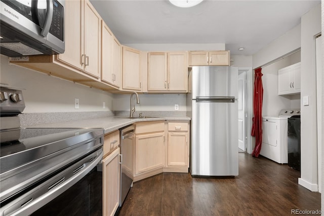 kitchen with light countertops, a sink, light brown cabinets, appliances with stainless steel finishes, and washer and dryer