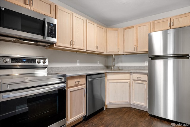kitchen with dark wood-type flooring, a sink, appliances with stainless steel finishes, and light brown cabinets