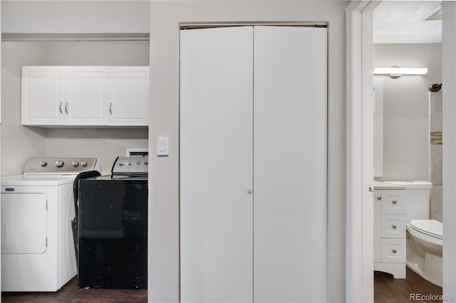 washroom with cabinet space, dark wood-style floors, and washer and dryer