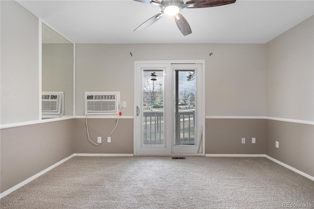 empty room with visible vents, a wall unit AC, carpet flooring, and a ceiling fan