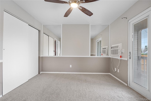 carpeted empty room with baseboards, a wall mounted air conditioner, and ceiling fan