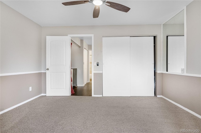 unfurnished bedroom with baseboards, a closet, dark colored carpet, and ceiling fan