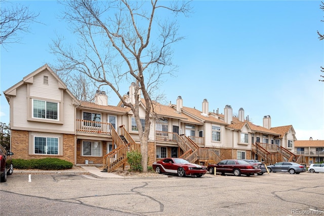 185 S Sable Blvd Unit T18, Aurora, CO 80012 - townhome / multi-family property featuring stairs, brick siding, a residential view, uncovered parking, and a chimney