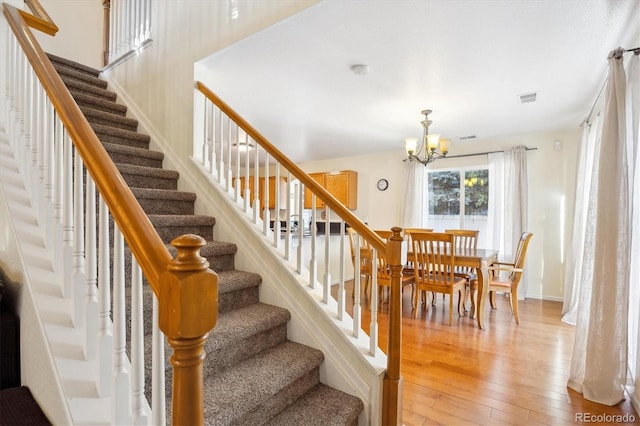 stairs with a chandelier and wood-type flooring