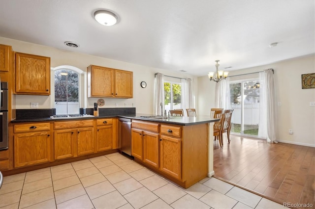 kitchen with sink, an inviting chandelier, stainless steel dishwasher, kitchen peninsula, and pendant lighting