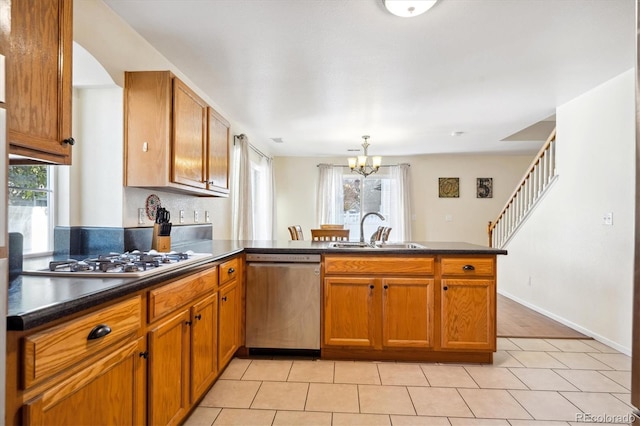 kitchen with kitchen peninsula, a wealth of natural light, sink, and appliances with stainless steel finishes