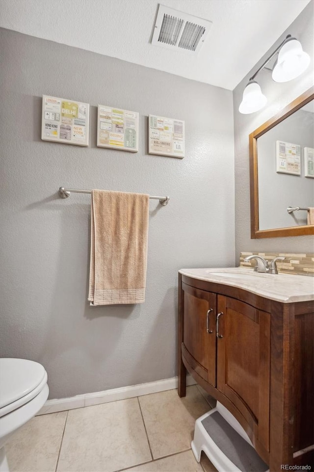 bathroom featuring tile patterned floors, vanity, and toilet