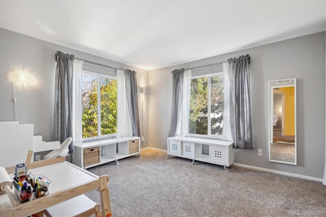 sitting room with carpet floors and a healthy amount of sunlight