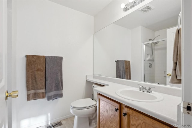 bathroom with vanity, a shower with shower door, and toilet