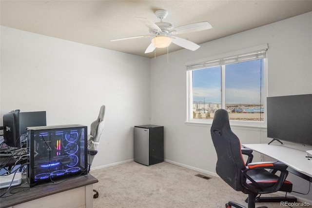 home office featuring light carpet and ceiling fan