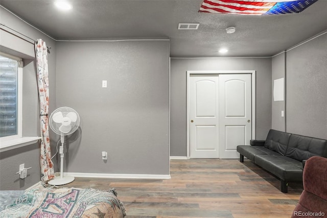 interior space with hardwood / wood-style floors, a closet, and a textured ceiling